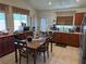 Functional kitchen with wood cabinetry, tile flooring, and a dining area perfect for Gathering meals at 9611 Sky Hollow Dr, Las Vegas, NV 89123