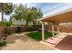 This backyard offers a covered patio, artificial turf, and a gravel area for a tranquil outdoor space at 9855 Ashton Pines Ct, Las Vegas, NV 89147