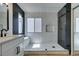 Modern bathroom featuring black and marble tile, a frameless glass shower, and light wood flooring at 9855 Ashton Pines Ct, Las Vegas, NV 89147