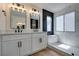 Bathroom featuring a double sink vanity, black fixtures, and a frameless glass shower with black and marble tile at 9855 Ashton Pines Ct, Las Vegas, NV 89147