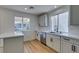 Bright kitchen features white cabinets, stainless steel appliances, quartz counters, and modern fixtures at 9855 Ashton Pines Ct, Las Vegas, NV 89147