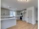 Bright, open kitchen featuring stainless steel appliances, light gray cabinets, and a spacious island with light wood floors at 9855 Ashton Pines Ct, Las Vegas, NV 89147