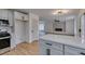 Open-concept kitchen and living room with stainless appliances and modern lighting at 9855 Ashton Pines Ct, Las Vegas, NV 89147