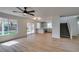 Bright living room featuring wood floors, ceiling fan, access to kitchen, and sliding glass door to backyard at 9855 Ashton Pines Ct, Las Vegas, NV 89147
