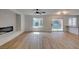 Spacious living room with wood flooring, fireplace, ceiling fan, and sliding glass doors to backyard at 9855 Ashton Pines Ct, Las Vegas, NV 89147