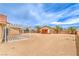 Spacious backyard featuring desert landscaping, a patio cover, a playhouse, and mature palm trees at , Pahrump, NV 89061