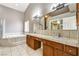 Bright bathroom featuring dual sinks, a soaking tub, and glass enclosed shower at , Pahrump, NV 89061
