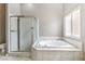 Bright bathroom featuring a glass enclosed shower, soaking tub, and large window with natural light at , Pahrump, NV 89061