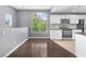 Open living space with hardwood floors and large windows overlooking mature trees and the kitchen at 10211 Red Pueblo Pl # 203, Las Vegas, NV 89144