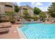 Community pool with chaise lounges and chairs at 10211 Red Pueblo Pl # 203, Las Vegas, NV 89144
