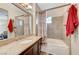 Bathroom featuring granite countertops, wood cabinets, and tiled shower with tub at 10372 Timber Canyon Ave, Las Vegas, NV 89129
