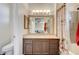 Well-lit bathroom featuring a large mirror, wood cabinets, and shower/tub combo at 10372 Timber Canyon Ave, Las Vegas, NV 89129
