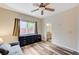 Bright bedroom featuring wood-look floors, ceiling fan, and view to bathroom at 10372 Timber Canyon Ave, Las Vegas, NV 89129