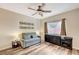 Bedroom with wood-look flooring, neutral walls, ceiling fan, and window at 10372 Timber Canyon Ave, Las Vegas, NV 89129