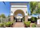 Elegant community entrance featuring a stone archway and manicured landscaping at 10372 Timber Canyon Ave, Las Vegas, NV 89129