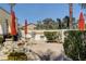 Outdoor seating with built in grill, tables, chairs, umbrellas, and mature landscaping in the background at 10372 Timber Canyon Ave, Las Vegas, NV 89129
