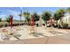 Outdoor seating area with tables, chairs, umbrellas, and lush landscaping near the pool at 10372 Timber Canyon Ave, Las Vegas, NV 89129