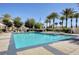 Sparkling community pool lined with palm trees, creating a tropical oasis for relaxation and recreation at 10372 Timber Canyon Ave, Las Vegas, NV 89129