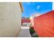 Narrow side yard featuring a bright red brick wall and minimal landscaping at 10372 Timber Canyon Ave, Las Vegas, NV 89129