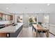 Modern kitchen with stainless steel appliances, wooden cabinetry, dining area and sliding door at 10376 Sadie Blake Ave, Las Vegas, NV 89166