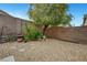 Landscaped backyard featuring gravel, stone pavers, and a mature tree that provides shade and natural beauty at 10929 Vallerosa St, Las Vegas, NV 89141