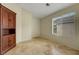 Bright, empty bedroom with neutral walls, tile floors, a window, and a dark wood cabinet at 10929 Vallerosa St, Las Vegas, NV 89141