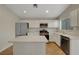 Bright kitchen features stainless steel appliances, white cabinets, a kitchen island, and tile flooring at 10929 Vallerosa St, Las Vegas, NV 89141