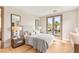 Bright bedroom featuring a king bed, wood floors, and doors to a private balcony at 11453 Glowing Sunset Ln, Las Vegas, NV 89135