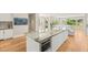 Spacious kitchen features white cabinets, an island with bar seating and built-in appliances, and wood floors at 11453 Glowing Sunset Ln, Las Vegas, NV 89135