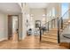 Elegant staircase and living area featuring light hardwood floors, high ceilings, and many arched windows at 11453 Glowing Sunset Ln, Las Vegas, NV 89135