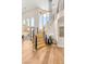 Sunlit curved staircase with hardwood treads and wrought iron railing leading to the upper level at 11453 Glowing Sunset Ln, Las Vegas, NV 89135