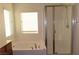 Bathroom featuring a soaking tub with tile surround and glass-enclosed shower at 117 Logan Pond Way, North Las Vegas, NV 89084
