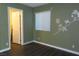 Bedroom with green walls, window, and light wood flooring with white trim at 117 Logan Pond Way, North Las Vegas, NV 89084