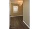 Bright bedroom featuring neutral walls, wood flooring, a chandelier, and a window for natural light at 117 Logan Pond Way, North Las Vegas, NV 89084