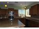 Kitchen area featuring wooden cabinets, backsplash and granite countertops, along with stainless steel appliances at 117 Logan Pond Way, North Las Vegas, NV 89084