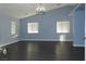 Spacious living room with dark laminate flooring, high ceilings, and a chandelier at 117 Logan Pond Way, North Las Vegas, NV 89084