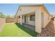Inviting backyard featuring a covered patio, low-maintenance artificial grass, and stone accents at 12426 Mosticone Way, Las Vegas, NV 89141