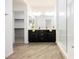 Stylish bathroom with dual sinks, dark cabinetry, wood-look tile flooring, and a glass shower at 12426 Mosticone Way, Las Vegas, NV 89141