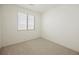 Cozy bedroom with neutral carpet, base trim, and a large window that brings in natural light at 12426 Mosticone Way, Las Vegas, NV 89141