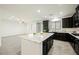 Open-concept kitchen featuring a center island, black cabinets, and stainless steel appliances at 12426 Mosticone Way, Las Vegas, NV 89141