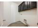 Functional laundry room with stylish gray flooring, black cabinets, and ample space for appliances at 12426 Mosticone Way, Las Vegas, NV 89141
