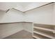 Well-organized walk-in closet with wooden rods, shelves, and neutral carpet at 12426 Mosticone Way, Las Vegas, NV 89141