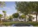 Expansive backyard featuring a trampoline, lush lawn, mature trees, and partial view of the home's exterior at 1610 Brock Ct, Las Vegas, NV 89117