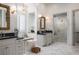 Luxurious bathroom boasts dual vanities, a soaking tub, and a glass-enclosed shower with marble tile at 1610 Brock Ct, Las Vegas, NV 89117