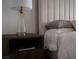 Bedroom detail featuring a stylish nightstand with a glass lamp and neutral color palette at 1610 Brock Ct, Las Vegas, NV 89117