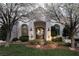 Charming home exterior with blooming trees, a manicured lawn, and a beautiful arched entryway at 1610 Brock Ct, Las Vegas, NV 89117