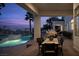 Covered outdoor dining area with a tranquil view of the pool, spa, and picturesque desert landscape at 1610 Brock Ct, Las Vegas, NV 89117