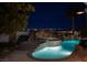 Picturesque outdoor pool and spa area with unique rock features and illuminated by elegant outdoor lighting at 1610 Brock Ct, Las Vegas, NV 89117