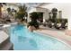 Backyard pool and tanning deck overlooking the landscaping and home beyond at 1610 Brock Ct, Las Vegas, NV 89117