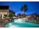 Stunning backyard pool and water slide in a luxury backyard setting at dusk at 1610 Brock Ct, Las Vegas, NV 89117